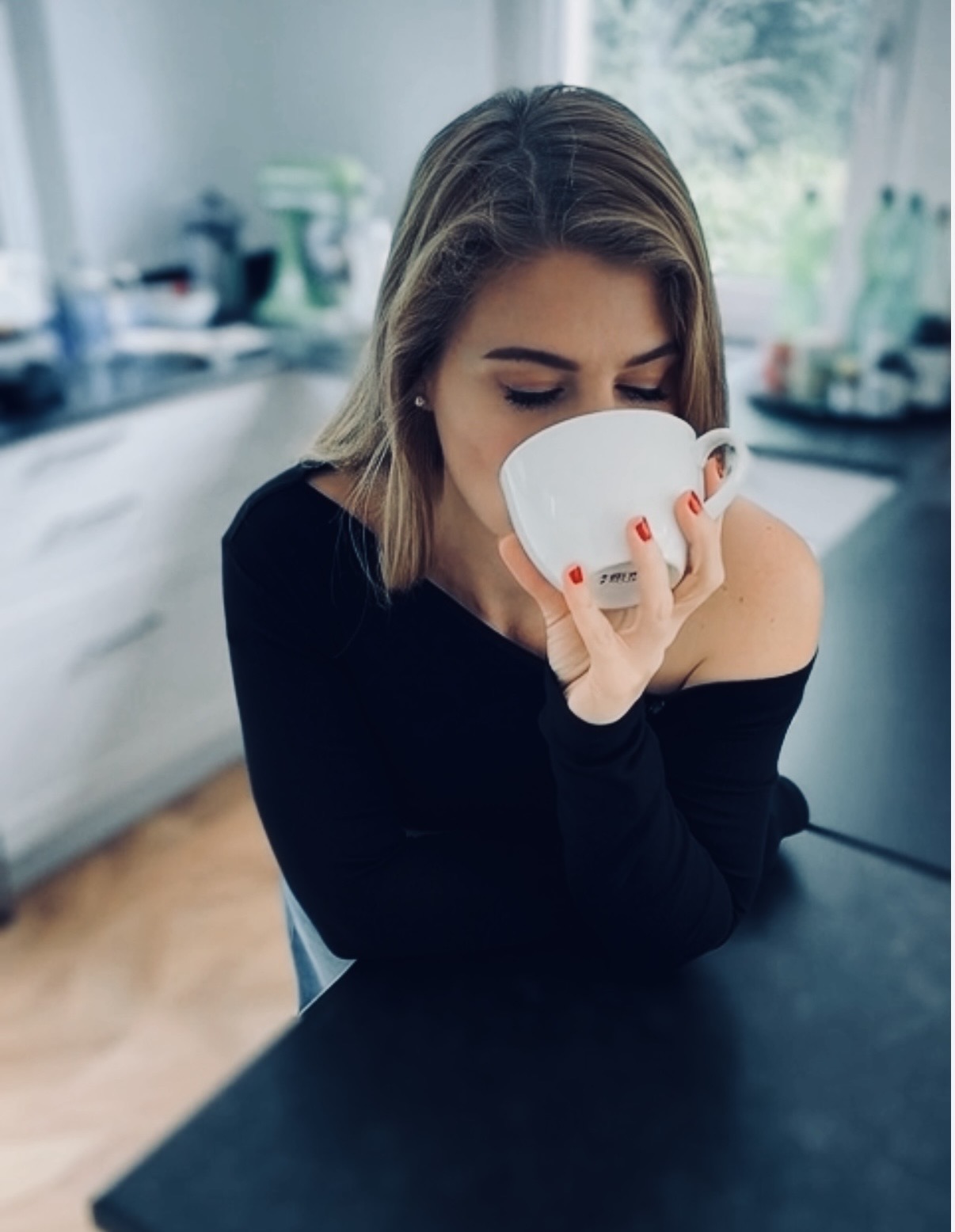 Yve mit weißer Kaffeetasse an einem ruhigen Morgen