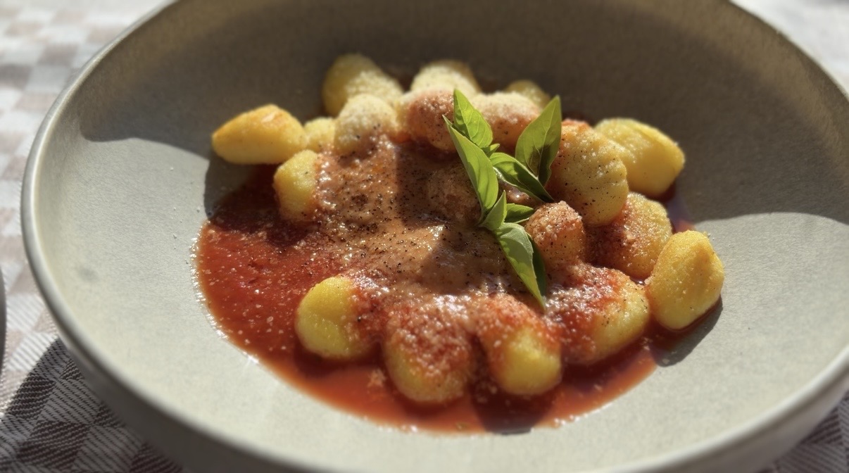 Fertige Gnocchi mit Tomatensoße, Parmesan und Basilikum im Keramikteller