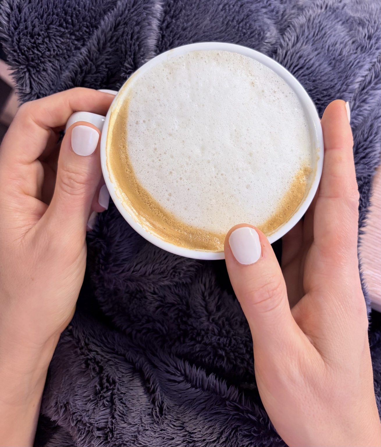 Hände mit warmer Cappuccinotasse